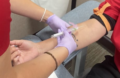 an image of a phlebotomist drawing blood from a patient