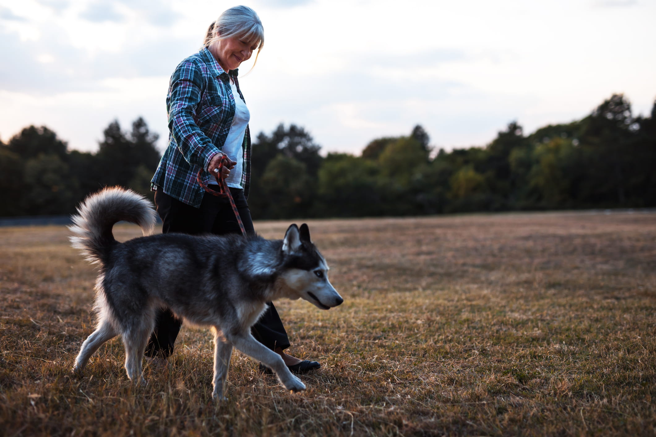 A woman with movement disorders walking her dog