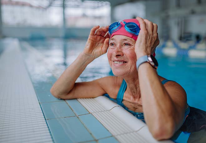 Elderly woman swimming and smiling