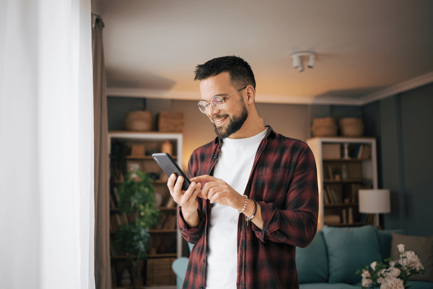 A man smiles while looking at his phone