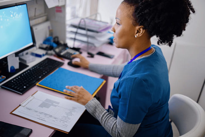 A hospital employee working at a computer