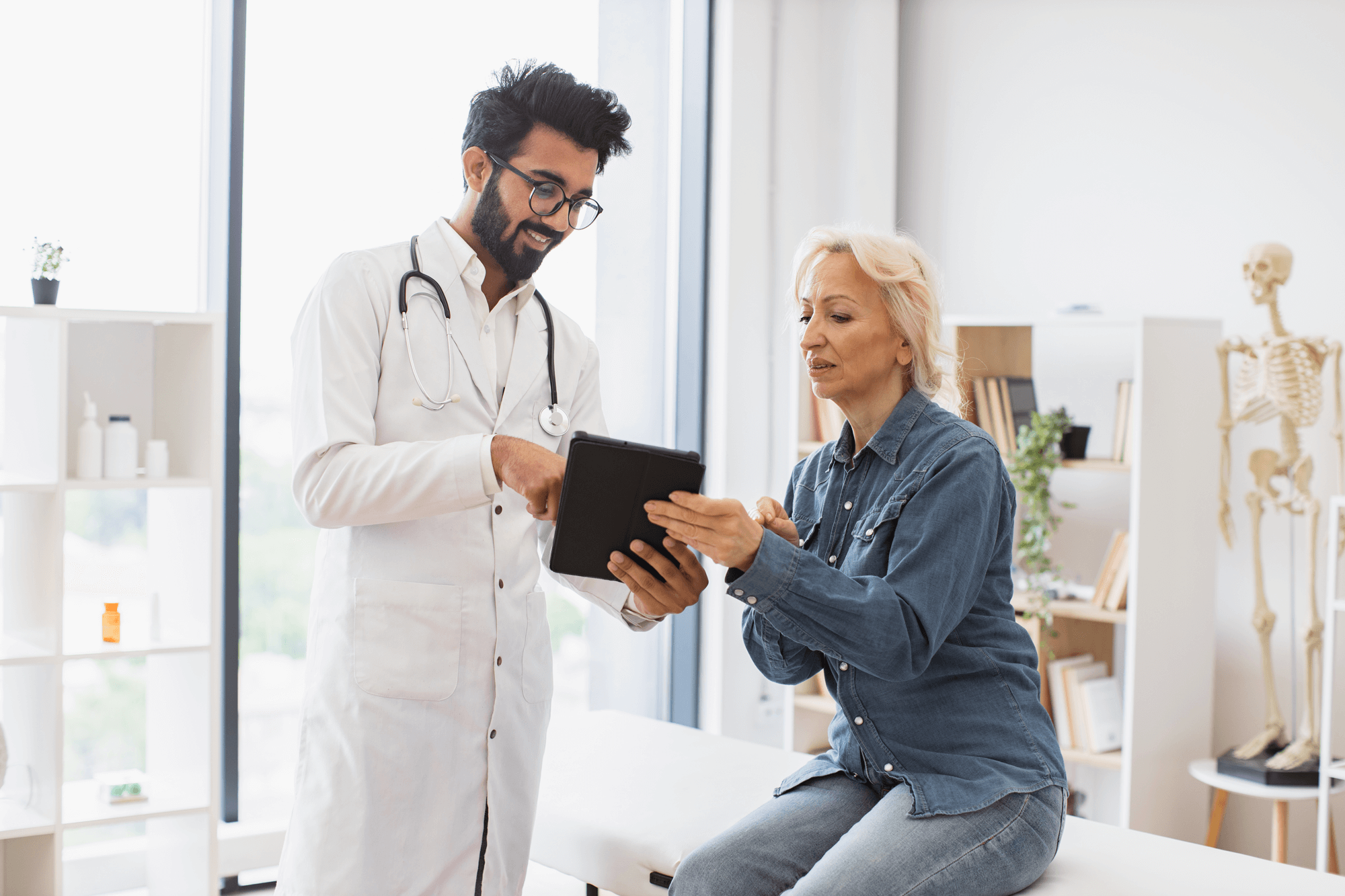 Un médico habla con un paciente para analizar los resultados en una tableta