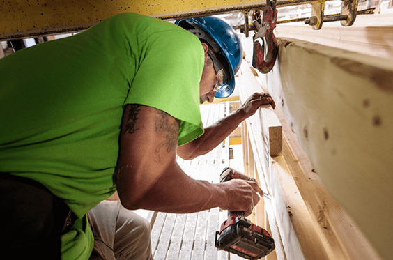 Un carpintero usando un taladro eléctrico en una obra en construcción
