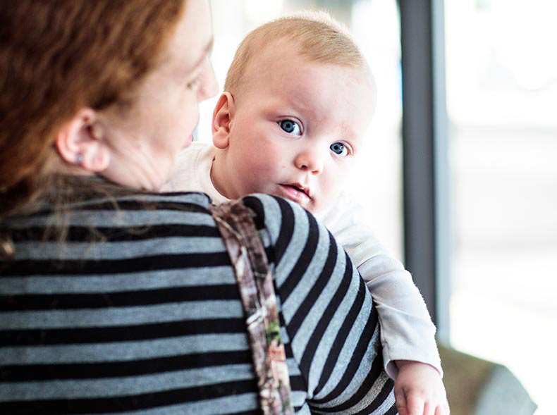 Image of baby looking over a woman's shoulder