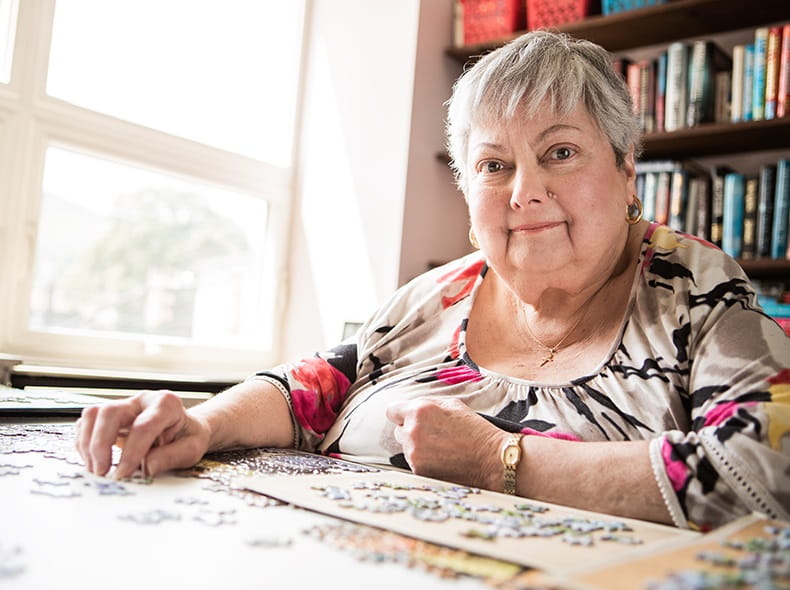 Joan Marie Roth working on a puzzle