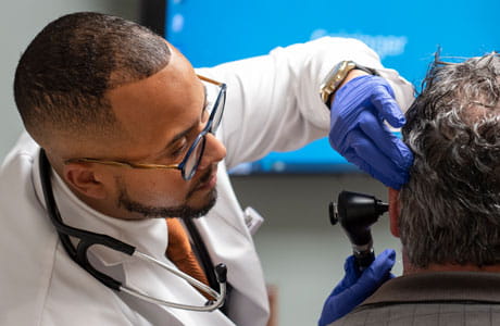 an image of a doctor looking in a patients ear