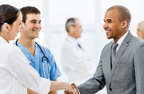 an image of a businessmen shaking hands with a doctor