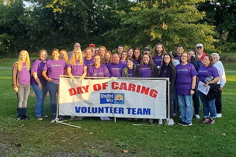 an image of students holding a Day of Caring sign