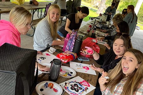 an image of students painting at the wellness day event. 