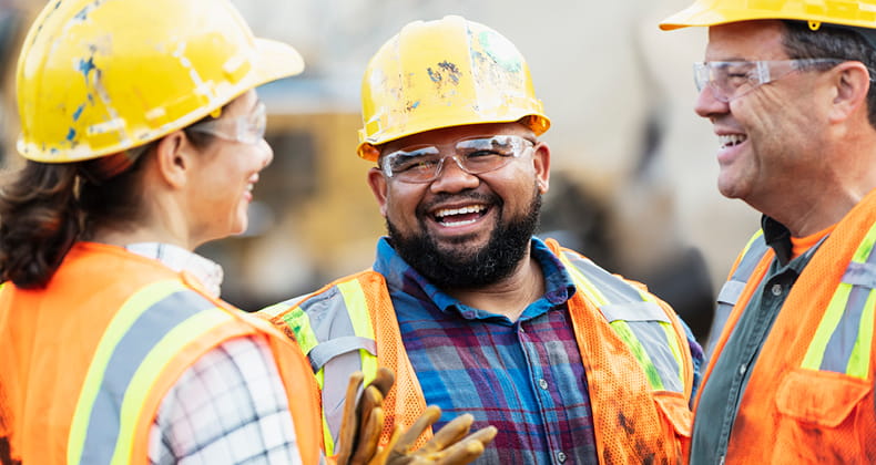 an image of three construction workers talking
