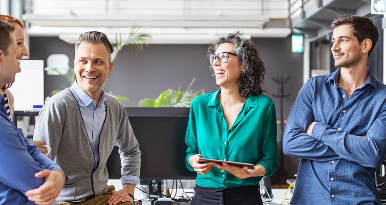 an image of employees chatting and smiling