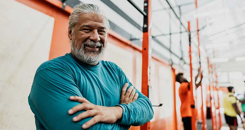 an older man smiling at the gym