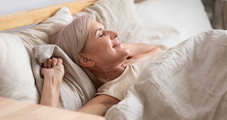 an image of an older woman in bed stretching