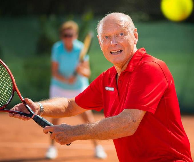 man in red polo playing tennis