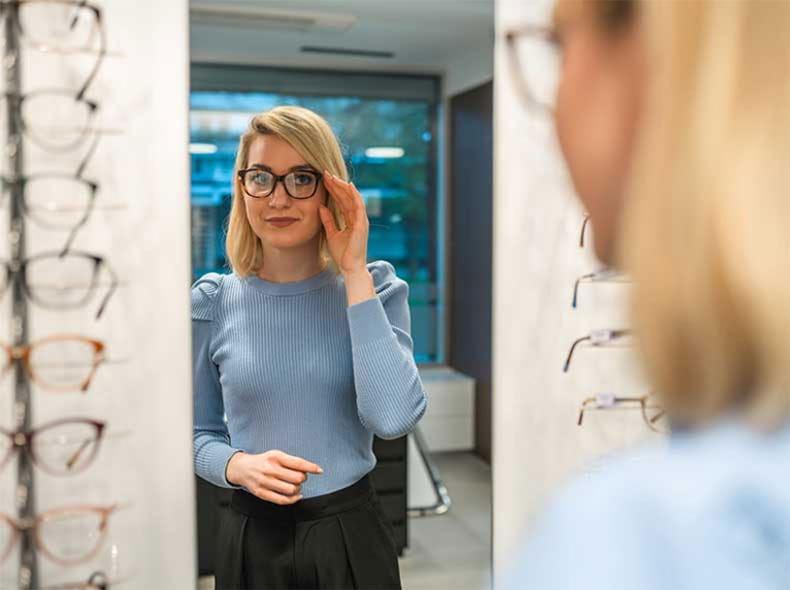 a women trying on glasses at a optical center