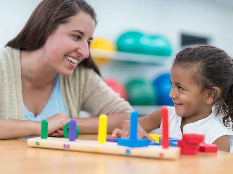 an occupational therapist helping a young child