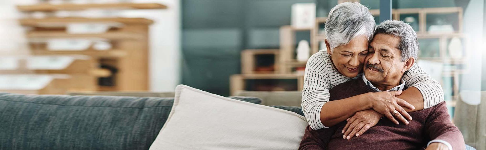 cheerful elderly woman hugging her husband