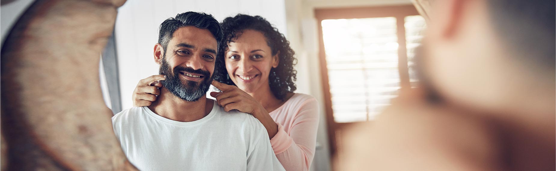 smiling couple looking in the mirror