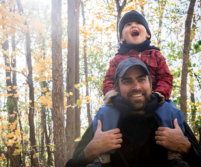 Father without shoulder or elbow pain giving his son a piggy back ride.