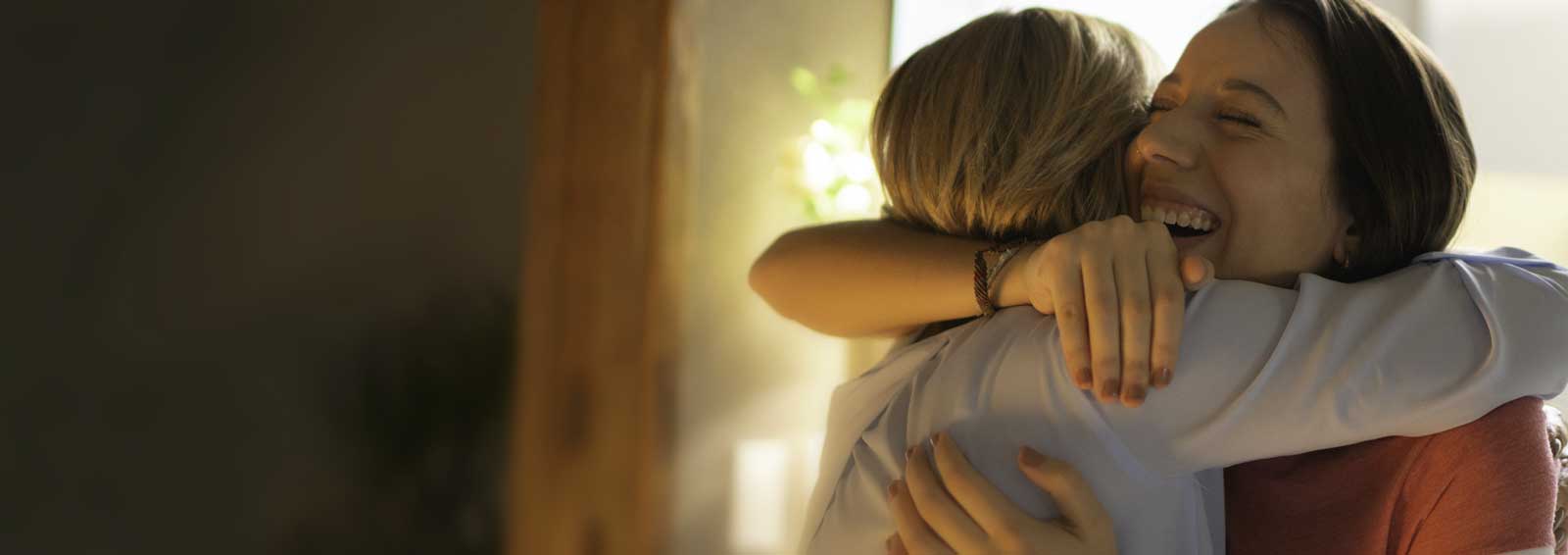 Two friends hugging and smiling