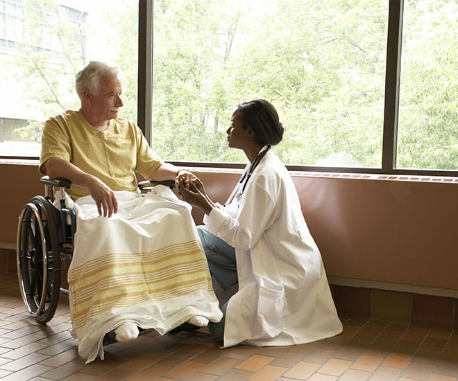 Doctor helping patient who is in a wheelchair