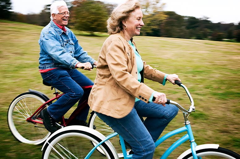 Couple enjoying a bike ride after full recovery from a kidney transplant surgery.