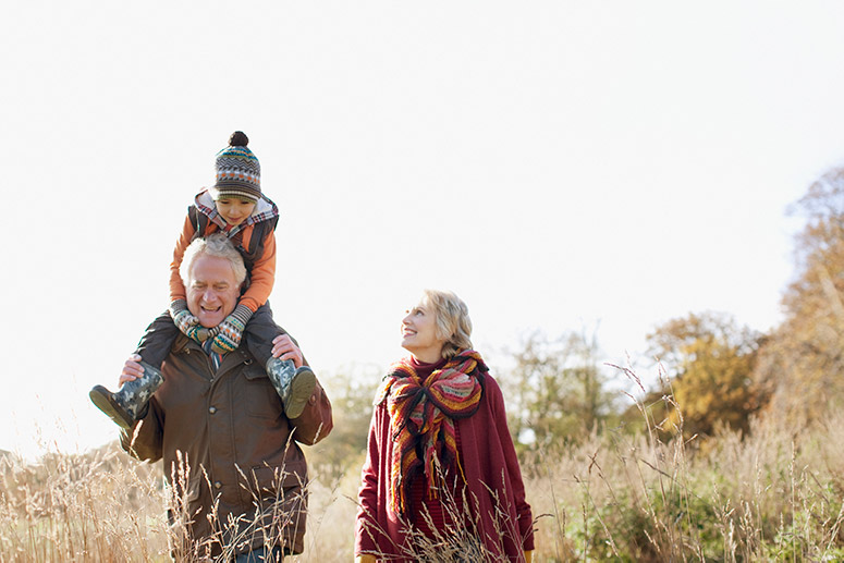Grandparents walking outdoors with grandson