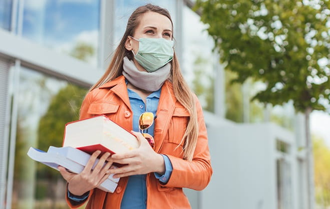 Woman in mask with text books