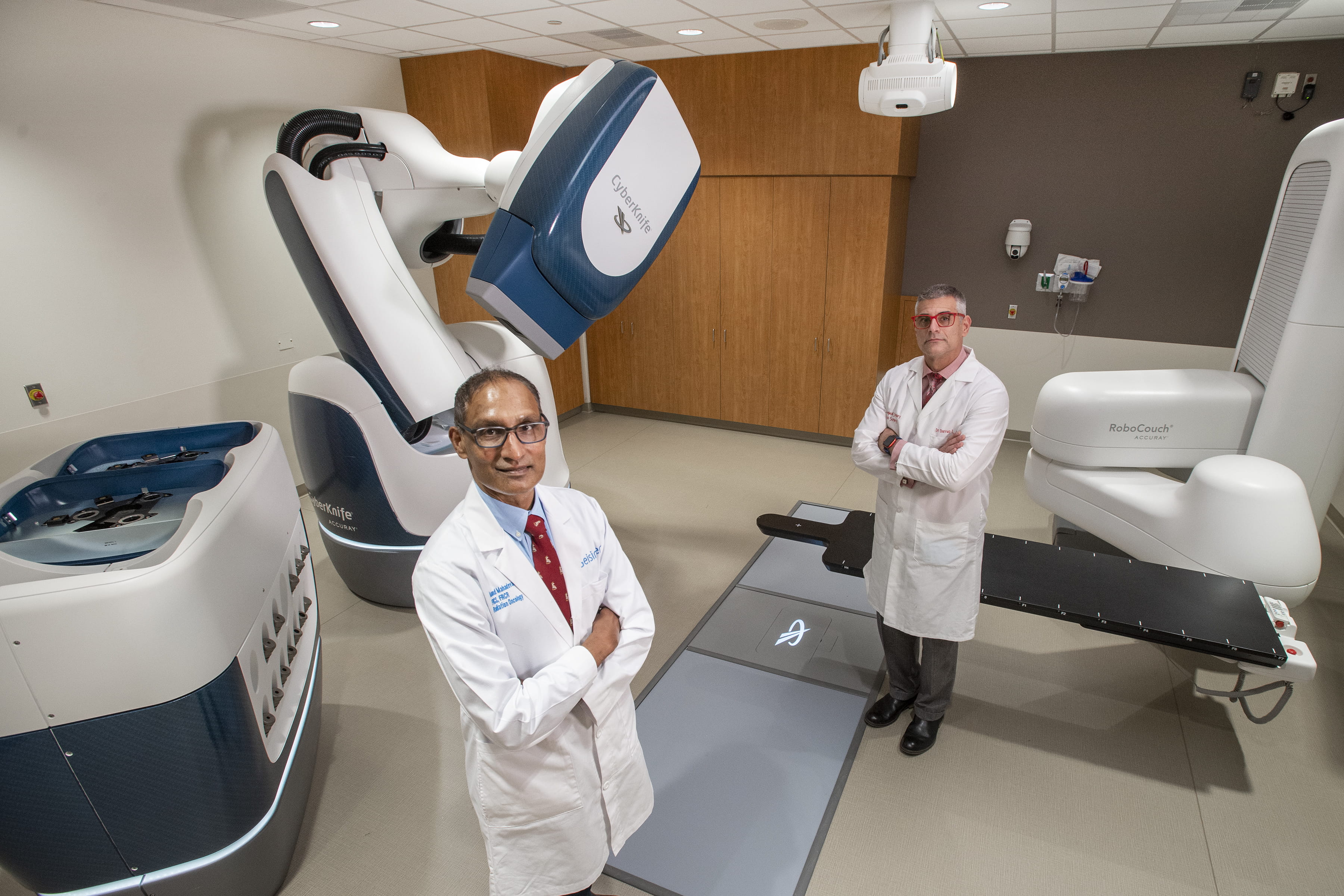 Two doctors standing in front of Cyberknife machine