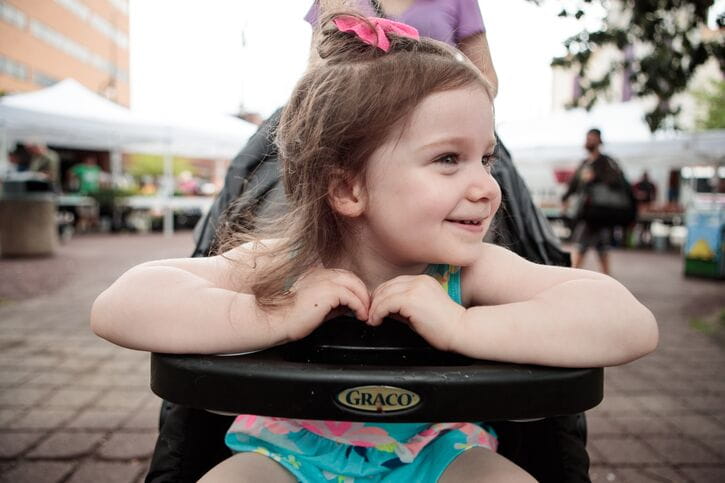 A smiling girl in a stroller