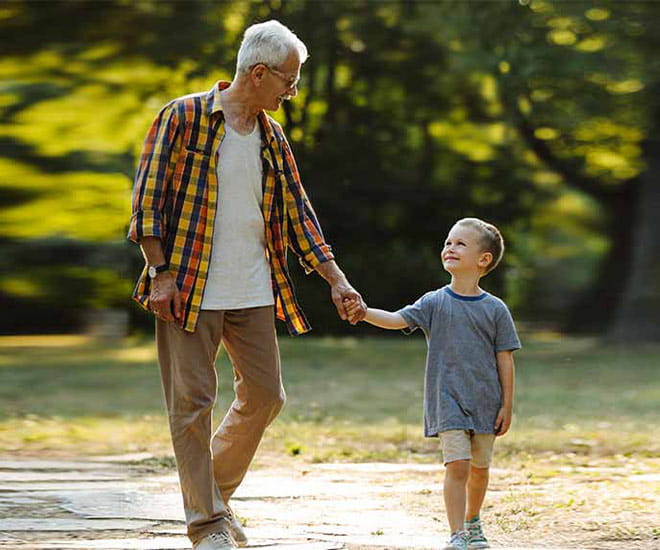 Grandfather and granson walking through the park