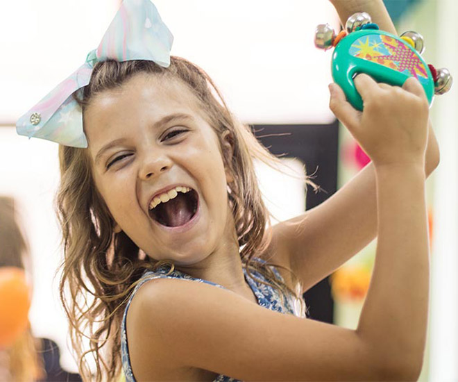 Child happy playing with a tamborine