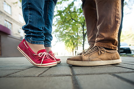 Image of teenagers feet standing on a sidewalk