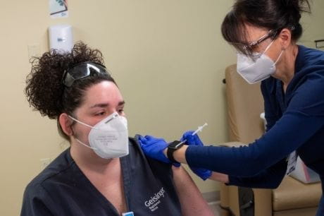 Nurse gives nurse a COVID vaccine.