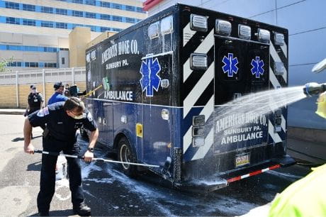Emergency medicine volunteers wash an ambulance outside of Geisinger Medical Center.