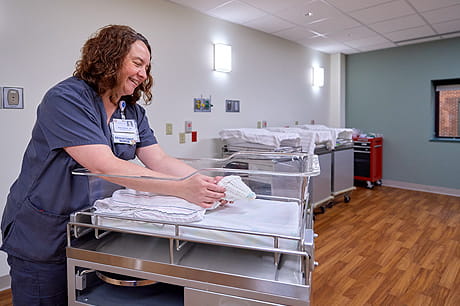 Nurse caring for an infant inside of a maternity room