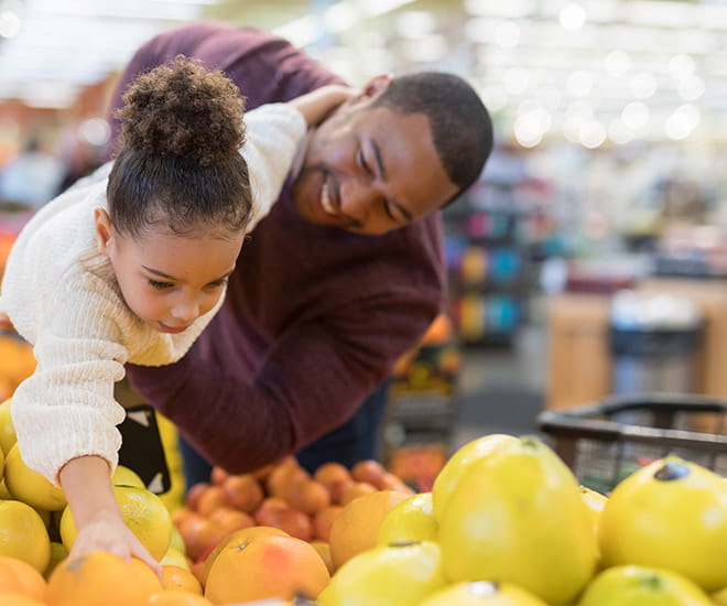 father and daughter picking out apples