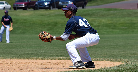 Baseball player crouched to catch the ball