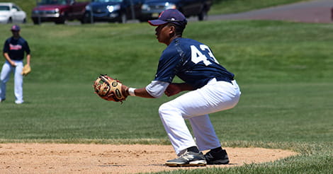 Baseball player crouched to catch the ball
