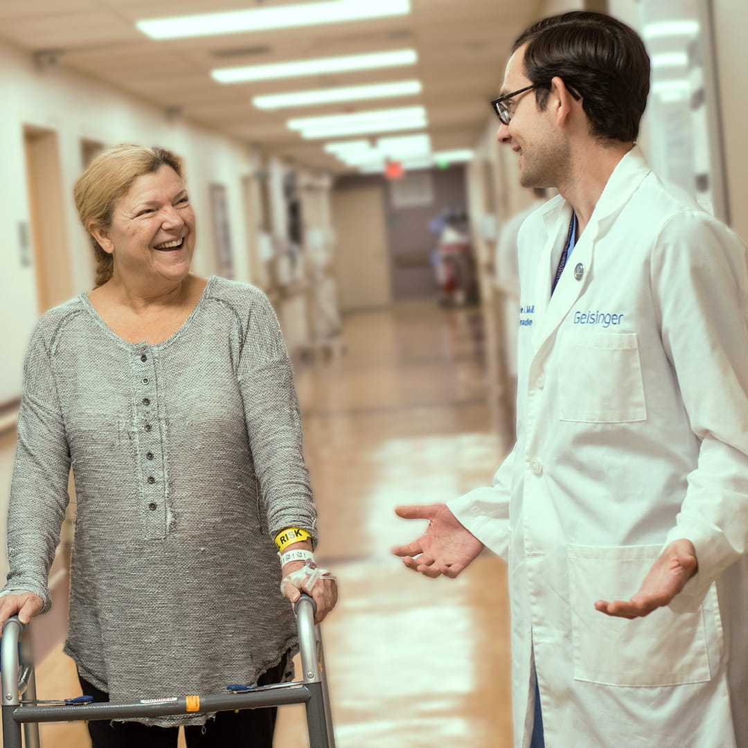 After receiving her Mako® robotic-arm–assisted joint replacement surgery, Rosanne walks with her surgeon.