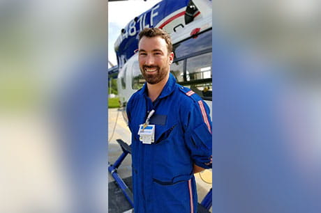 Alex Haines, RN, flight nurse with Geisinger LifeFlight, stands next to the LifeFlight helicopter.