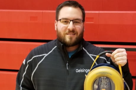 Geisinger certified athletic trainer Joseph Rosell with his automated external defibrillator (AED).