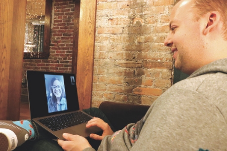 Andrew Yurkanin sits with his computer, video chatting with his kidney donor, Kelsey Leva.