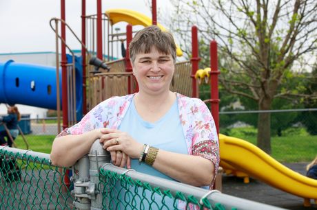 Leslie Sheaffer of Reedsville standing at a fence in a children’s playground after her hip replacement surgery.