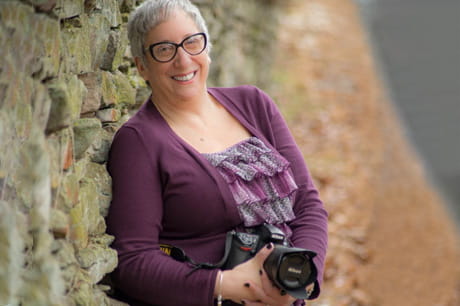 Lori Prashker-Thomas, co-owner of ShadowCatcher Photography LLC, holding a camera