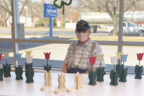65 Forward participant with wood carvings