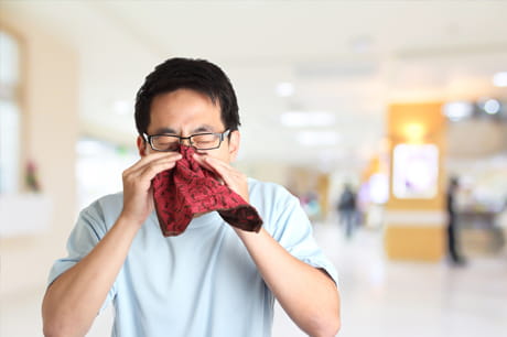 Man sneezing in handkerchief 
