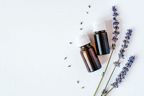 Dried lavender around essential oil bottles.