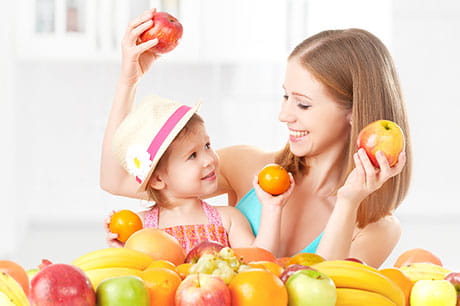 mom with daughter holding fruit