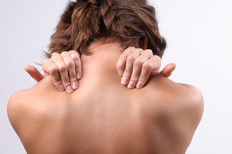 Woman squeezing shoulders in pain